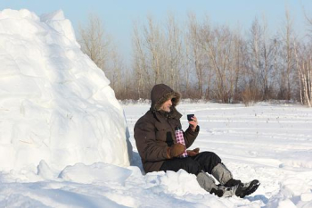 Zdjęcie przedstawia pana siedzącego na śniegu trzymającego termos z napojem. zródło: pixabay.